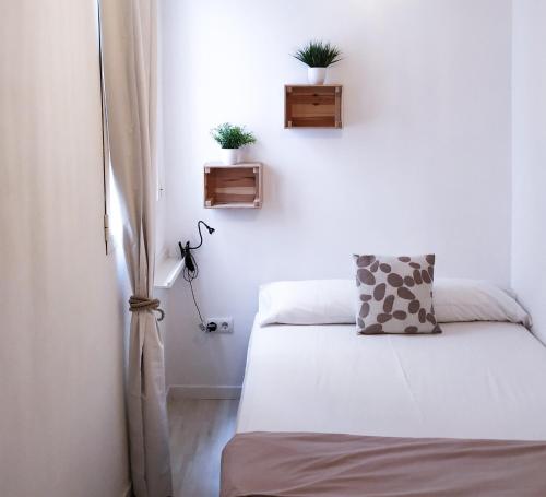 a bedroom with two beds and two plants on the wall at Casa Acosta in Madrid