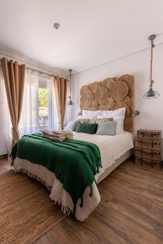 a bedroom with a large bed with a green blanket at Casa da Mó - Douro in Armamar