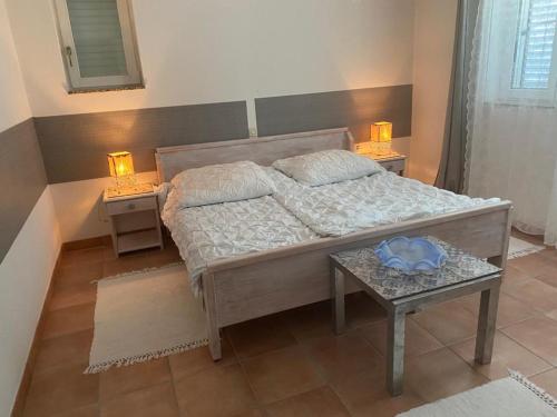 a bedroom with a bed and a table with two lamps at Casa Fumica Apartment in Palit