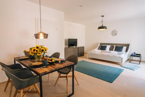 a living room with a table and chairs and a bed at Wave Penthouses in Neusiedl am See
