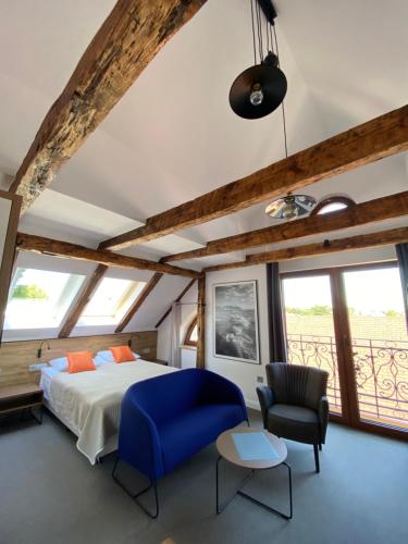a bedroom with a bed and a blue chair at Willa Oktawia in Niechorze