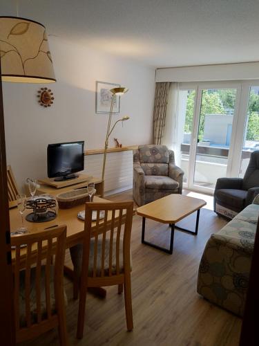 ein Wohnzimmer mit einem Tisch und einem Sofa in der Unterkunft Fortuna 404 in Leukerbad