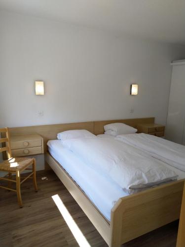 a bedroom with a large bed and a chair at Fortuna 404 in Leukerbad
