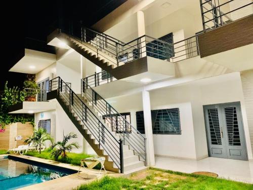 a house with a staircase and a swimming pool at Quatre appartements en location a Saly-Senegal in Saly Portudal
