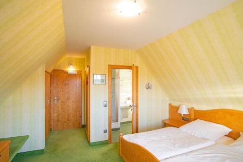 A bed or beds in a room at Hotel-Pension Eschwege