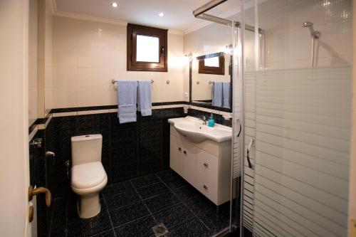 ein Bad mit einem WC und einem Waschbecken in der Unterkunft G and A House in Póros