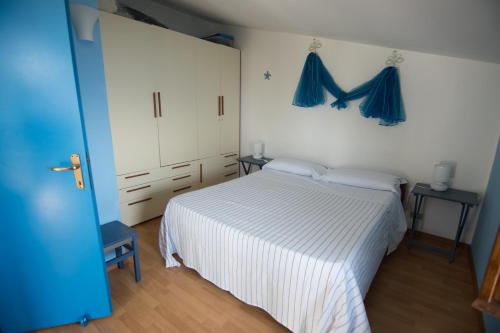 a bedroom with a white bed and blue curtains at Il Sole di Valletonda Holiday House in Corniglia