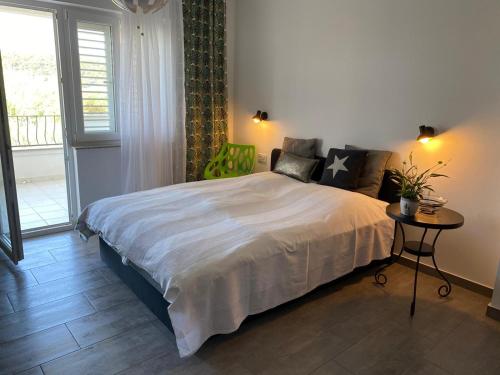 a bedroom with a bed and a table and a window at Casa Fumica Studio in Kampor