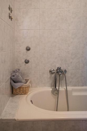 a bath tub in a bathroom with a shower at Guesthouse Pupa Opatija Istra in Jurdani