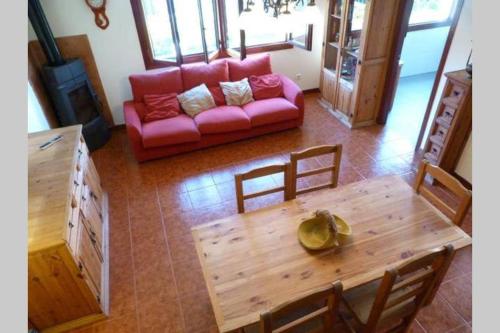 uma sala de estar com um sofá vermelho e uma mesa de madeira em CHALET FAMILIAS 10 Huéspedes Beranga Noja Playas, Mascotas bienvenidas em Beranga