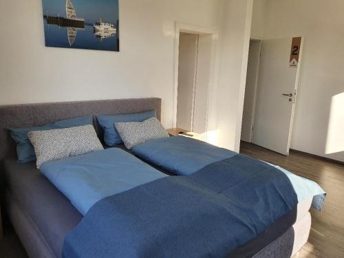 a bedroom with two beds with blue sheets at Inselkern Einraum-Apartments in Juist