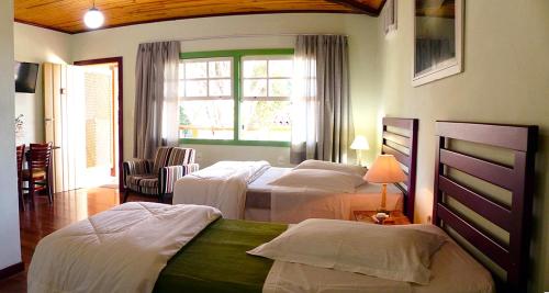 een hotelkamer met 2 bedden en een raam bij Pouso da Chica in Diamantina