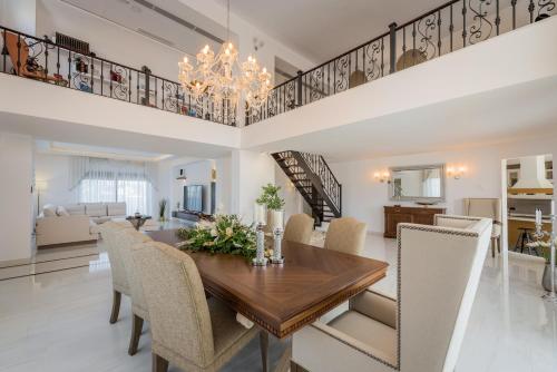 a dining room with a wooden table and chairs at Villa Shangri-La Zakinthos in Zakynthos Town