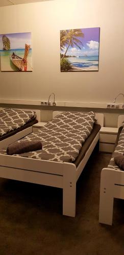 a bedroom with two beds and a painting on the wall at Agro Relax Nowodwór 2 in Nowodwór