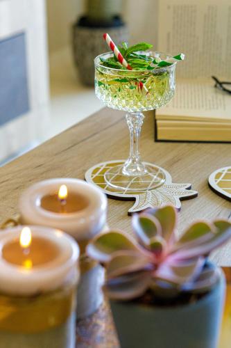 a table with a wine glass and candles on it at Savvas Apartment in Tolo