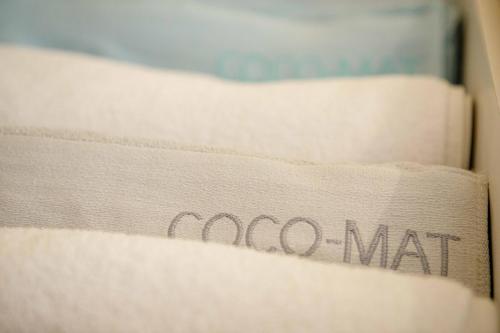 a stack of white towels with the word cocoa mat on them at Savvas Apartment in Tolo