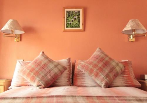 a bedroom with orange walls and a bed with pillows at Haven Crest in Whitby