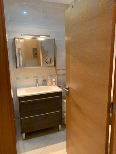 a bathroom with a sink and a mirror at Fantastic Fatima Apartment in Vila Real de Santo António