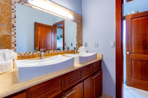 uma casa de banho com 2 lavatórios e um espelho grande em 1-Bedroom Ocean-View Condo with Pool em Playa Flamingo
