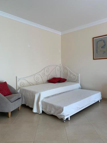 a bedroom with two beds and a chair at Fantastic Fatima Apartment in Vila Real de Santo António