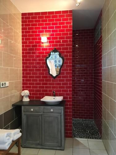 baño con pared de ladrillo rojo y lavamanos en Gîte piscine jacuzzi privatisés Clos Valentin, en Freulleville