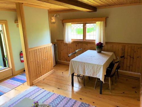 ein Esszimmer mit einem Tisch und einem Fenster in der Unterkunft Villa Klockarbo - Stugor - Cabins in Tällberg