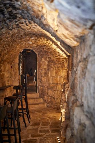 a tunnel with chairs and tables in a stone wall at Chateau du Roi in Mi‘ilyā