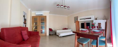 a living room with a red couch and a table at Fantastic Fatima Apartment in Vila Real de Santo António
