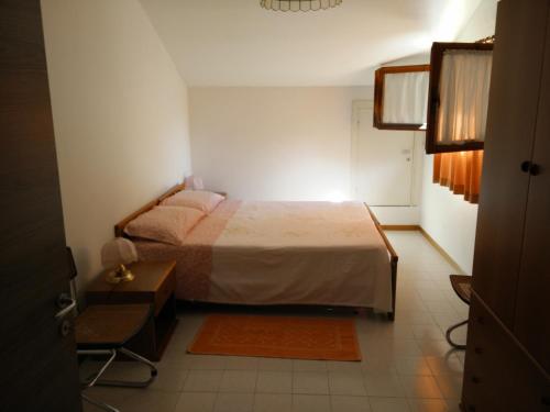 een slaapkamer met een bed en een stoel erin bij CASA VACANZE ARBORIAMAR SORSO SARDEGNa in Marina di Sorso