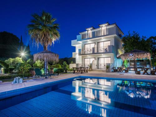 a villa with a swimming pool at night at Mon Repo Suites in Laganas