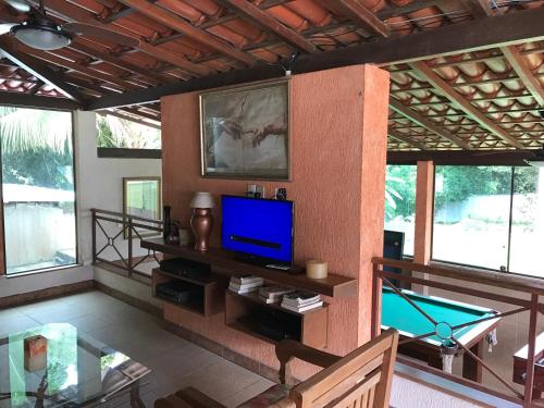 a living room with a tv and a pool table at Pousada Doce Vida Guarapari in Guarapari