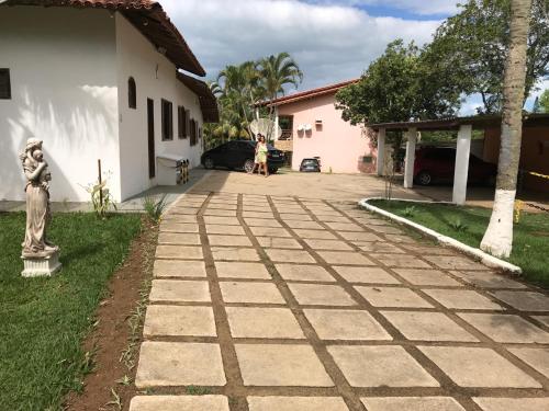 a person standing in the driveway of a house at Pousada Doce Vida Guarapari in Guarapari