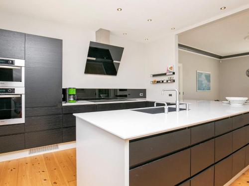eine Küche mit einer weißen Arbeitsplatte und schwarzen Schränken in der Unterkunft 12 person holiday home in Nyborg in Nyborg