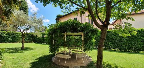 a table and chairs under an arch in a yard at B&B Le Palme in Appiano Gentile