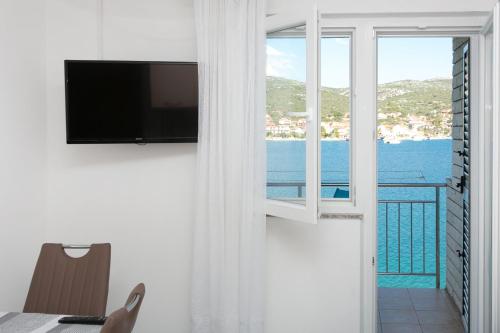 a room with a window with a view of the ocean at Apartments Babin in Vinišće