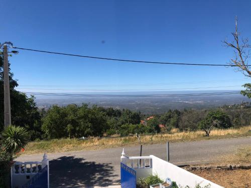 a view of a road from a hill with a blue sky at VIVENDA AZUL in Monchique