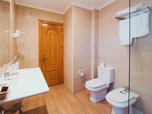 uma casa de banho com um WC, um lavatório e um espelho. em Hotel Doña Carmen nas Tordesilhas