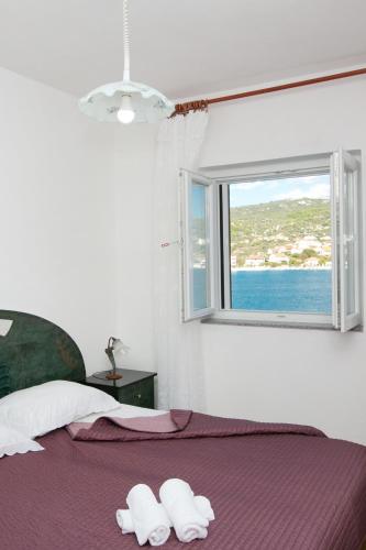 a bedroom with a bed with two towels on it at Apartments Babin in Vinišće