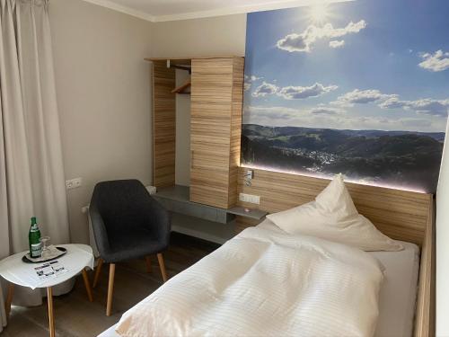 a bedroom with a bed and a desk and a painting at Landgasthof Zur Erholung in Breitscheid