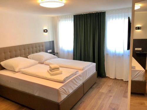 una camera da letto con un letto con lenzuola bianche e uno specchio di City Apartments, Outlet 100 Meter a Metzingen