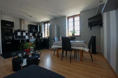 une cuisine et une salle à manger avec une table et des chaises dans l'établissement F2 Aux pieds des Thermes 3 étoiles, à Luxeuil-les-Bains