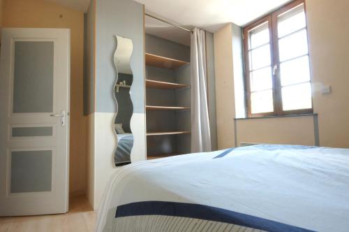 1 dormitorio con cama y estante para libros en F2 Aux pieds des Thermes 3 étoiles en Luxeuil-les-Bains