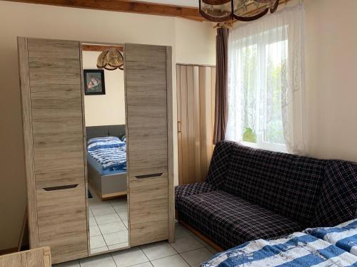 a bedroom with a large wooden cabinet next to a bed at Bialy domek in Rowy