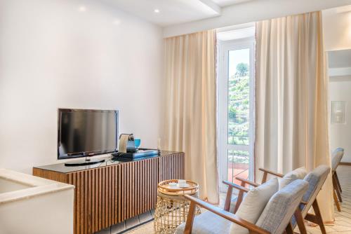 a living room with a flat screen tv and chairs at La Torretta Lodge in Manarola