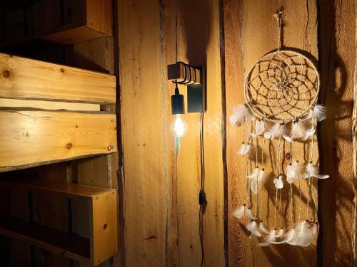 a wall with a dream catcher and a light on it at Arctic Lodges Lapland Ski in, slopes, ski tracks, National Park, free Wi-Fi - Lapland Villas in Pyhätunturi