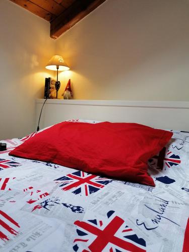 een rood kussen op een bed met Britse vlaggen erop bij Theatrum in Aosta