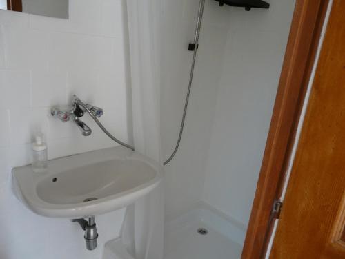 a white sink in a bathroom with a shower at Mi-Ri Balance vendégház in Szinpetri
