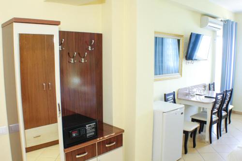 a kitchen with a table and chairs and a refrigerator at Republika Hotel in Sarandë