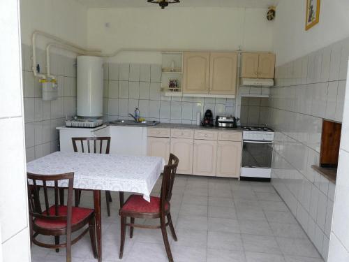 a kitchen with a table and chairs and a stove at Mi-Ri Balance vendégház in Szinpetri