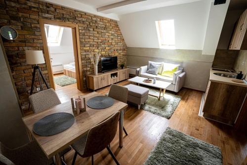 a living room with a table and a brick wall at All Seasons Residence in Zlatibor